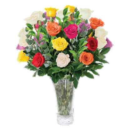 A vibrant mixed bouquet of single roses in yellow, orange, red, pink, and white, arranged with green foliage in a clear fluted glass vase against a plain white background.